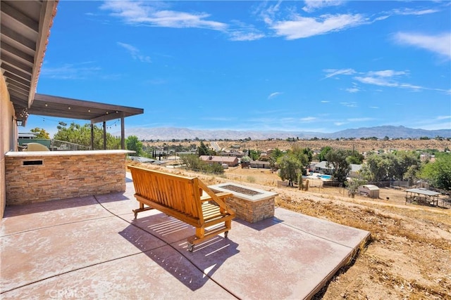 8383 Buckthorn Ave, Hesperia, CA 92345 - view of patio with a mountain view, a fire pit, and an outdoor kitchen