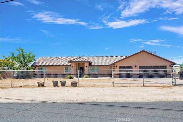 8383 Buckthorn Ave, Hesperia, CA 92345 - view of front facade featuring concrete driveway, a fenced front yard, an attached garage, stucco siding, and a tiled roof