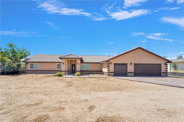 8383 Buckthorn Ave, Hesperia, CA 92345 - view of front of house with a tile roof, an attached garage, driveway, and stucco siding
