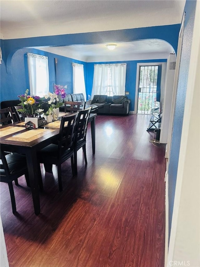 418 W 103rd St, Los Angeles, CA 90003 - dining space with arched walkways and dark wood-style flooring