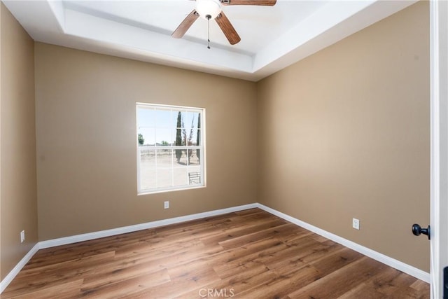 13212 Primavera Rd, Pinon Hills, CA 92372 - empty room featuring a raised ceiling, wood finished floors, and a ceiling fan