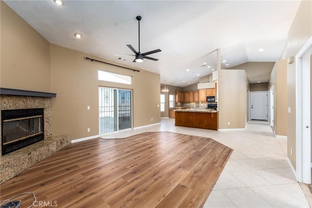 13212 Primavera Rd, Pinon Hills, CA 92372 - unfurnished living room featuring a ceiling fan, lofted ceiling, a tiled fireplace, recessed lighting, and light tile patterned flooring