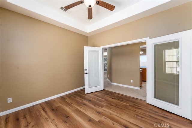 13212 Primavera Rd, Pinon Hills, CA 92372 - spare room with a ceiling fan, wood finished floors, and a raised ceiling
