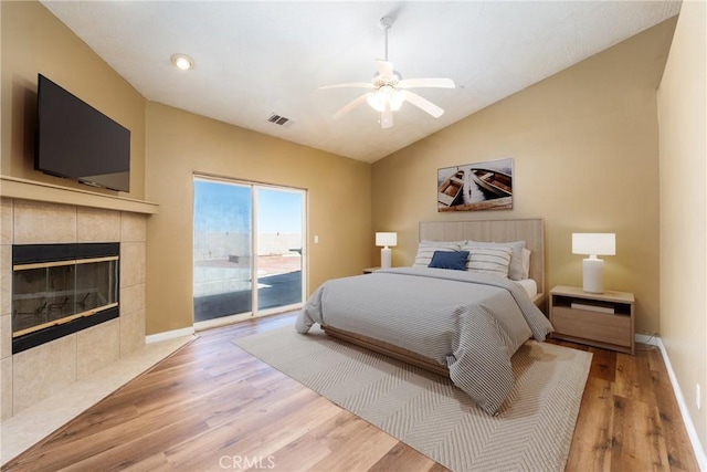 13212 Primavera Rd, Pinon Hills, CA 92372 - bedroom with access to exterior, lofted ceiling, light wood-style flooring, a fireplace, and a ceiling fan