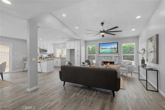 6831 Valinda Ave, Rancho Cucamonga, CA 91701 - living area with a ceiling fan, lofted ceiling, light wood-style flooring, a fireplace, and plenty of natural light