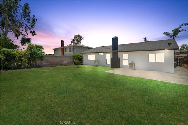 6831 Valinda Ave, Rancho Cucamonga, CA 91701 - back of house at dusk with a patio, a chimney, and stucco siding