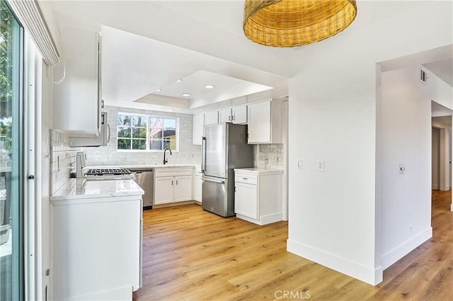 33621 Blue Lantern St, Dana Point, CA 92629 - kitchen featuring stainless steel appliances, backsplash, light countertops, light wood-style floors, and white cabinets