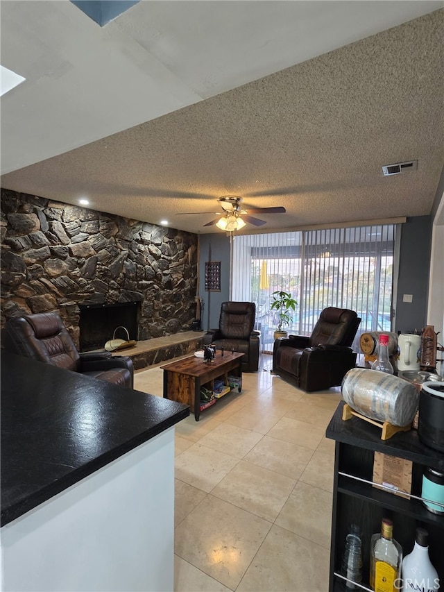 11815 Arliss Way, Grand Terrace, CA 92313 - living room featuring light tile patterned floors, a textured ceiling, a ceiling fan, and a fireplace