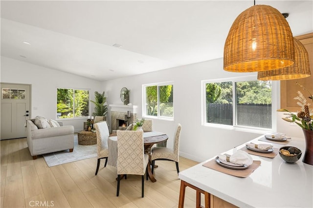26871 Via Santa Lucia, Mission Viejo, CA 92691 - dining space featuring light wood-style floors, plenty of natural light, a warm lit fireplace, and lofted ceiling