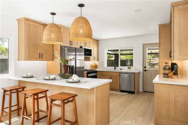 26871 Via Santa Lucia, Mission Viejo, CA 92691 - kitchen featuring appliances with stainless steel finishes, a peninsula, a breakfast bar, light wood finished floors, and light countertops