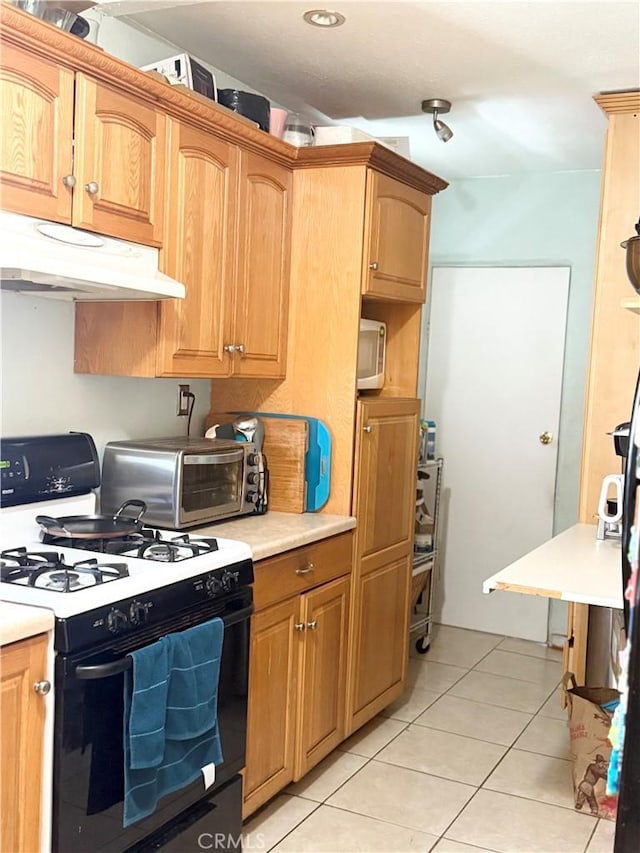 516 N Brand Blvd, San Fernando, CA 91340 - kitchen with gas stove, under cabinet range hood, light countertops, and light tile patterned flooring