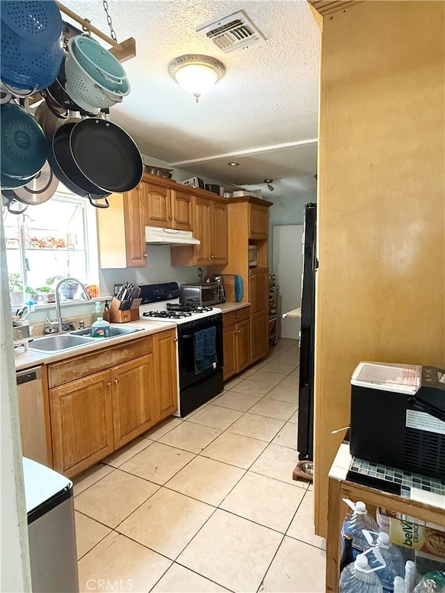516 N Brand Blvd, San Fernando, CA 91340 - kitchen with black appliances, under cabinet range hood, light countertops, a textured ceiling, and light tile patterned floors
