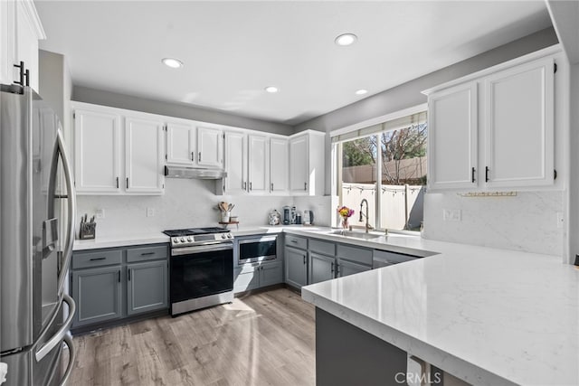 17656 Gladesworth Ln, Canyon Country, CA 91387 - kitchen featuring appliances with stainless steel finishes, gray cabinets, under cabinet range hood, light countertops, and recessed lighting