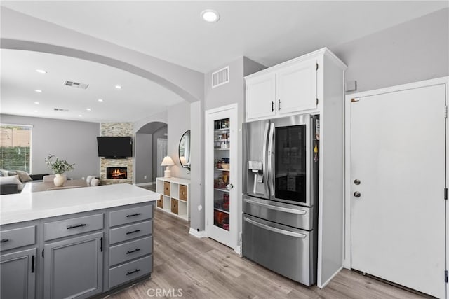 17656 Gladesworth Ln, Canyon Country, CA 91387 - kitchen featuring stainless steel refrigerator with ice dispenser, gray cabinetry, a fireplace, light wood-style floors, and open floor plan
