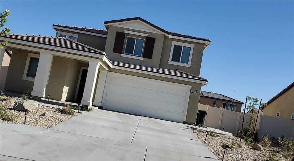 10562 Chevron Ct, Adelanto, CA 92301 - traditional-style house featuring stucco siding, concrete driveway, an attached garage, and a tile roof