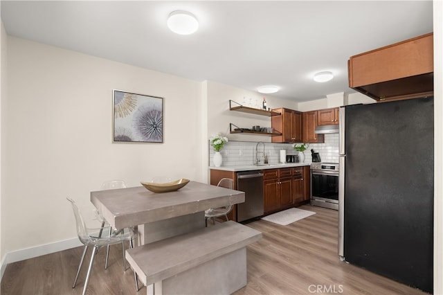 341 Carriage Dr Unit 51-A, Santa Ana, CA 92707 - kitchen with appliances with stainless steel finishes, open shelves, tasteful backsplash, light wood-type flooring, and light countertops