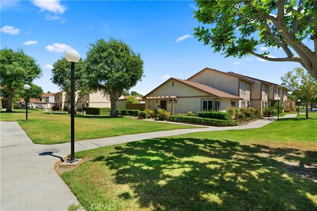 341 Carriage Dr Unit 51-A, Santa Ana, CA 92707 - view of front of house with stucco siding, a front lawn, and a residential view