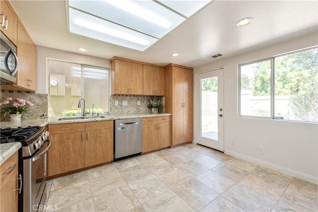 120 Rue Monet, Lake Forest, CA 92610 - kitchen with appliances with stainless steel finishes, backsplash, recessed lighting, and light stone counters