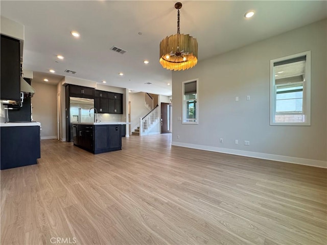 325 Sawbuck, Irvine, CA 92618 - kitchen with light countertops, open floor plan, light wood-style flooring, exhaust hood, and a center island with sink