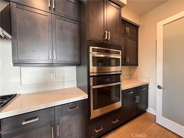 325 Sawbuck, Irvine, CA 92618 - kitchen with double oven, light wood-style flooring, and dark brown cabinets