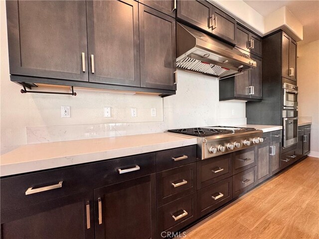 325 Sawbuck, Irvine, CA 92618 - kitchen featuring under cabinet range hood, stainless steel gas cooktop, light wood-type flooring, light countertops, and dark brown cabinetry
