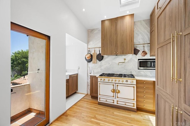 1683 Linwood St, San Diego, CA 92103 - kitchen with stainless steel microwave, cooktop, light countertops, light wood-type flooring, and backsplash