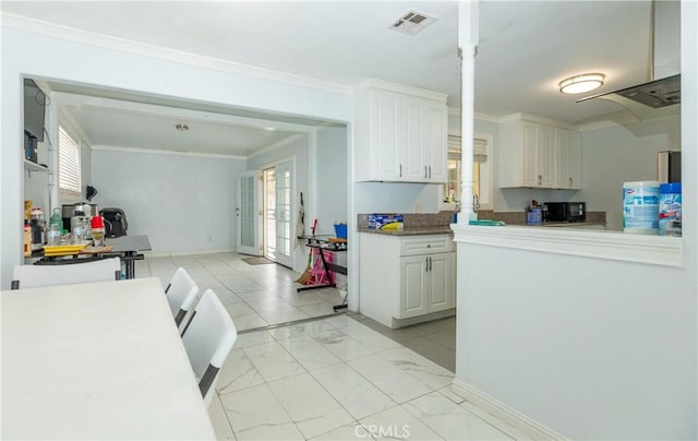 2820 S M St, Oxnard, CA 93033 - kitchen featuring plenty of natural light, white cabinetry, light marble finish floors, crown molding, and black microwave
