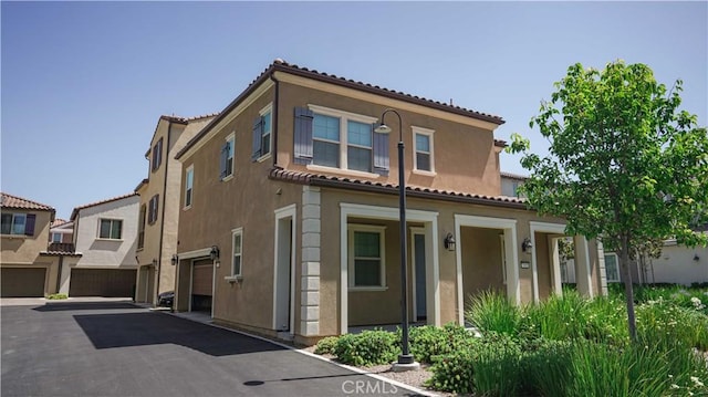 7600 Channel View St, Chino, CA 91708 - view of front facade featuring a tile roof, an attached garage, and stucco siding