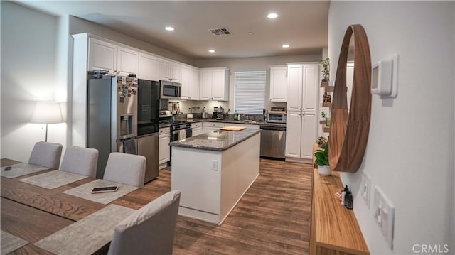 7600 Channel View St, Chino, CA 91708 - kitchen with appliances with stainless steel finishes, a kitchen island, white cabinetry, dark wood-style floors, and recessed lighting