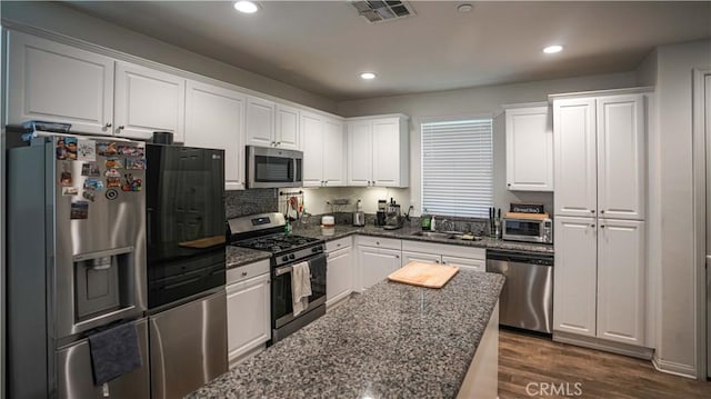 7600 Channel View St, Chino, CA 91708 - kitchen featuring appliances with stainless steel finishes, white cabinetry, dark stone countertops, and recessed lighting