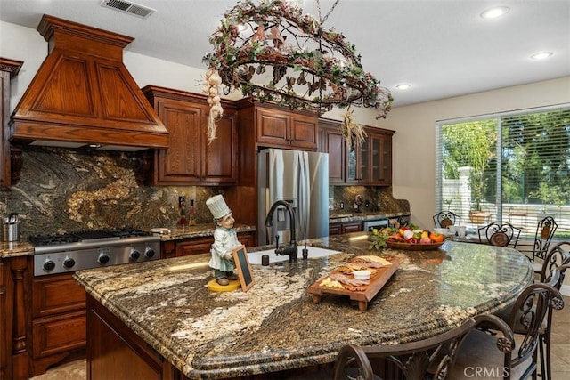 32974 Anasazi Dr, Temecula, CA 92592 - kitchen featuring appliances with stainless steel finishes, premium range hood, an island with sink, recessed lighting, and decorative backsplash