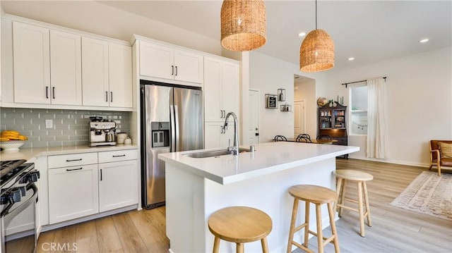 4173 Horvath St Unit 105, Corona, CA 92883 - kitchen featuring stainless steel fridge with ice dispenser, gas stove, light wood-type flooring, light countertops, and a breakfast bar