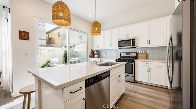 4173 Horvath St Unit 105, Corona, CA 92883 - kitchen with stainless steel appliances, decorative backsplash, light wood-style flooring, light countertops, and white cabinetry
