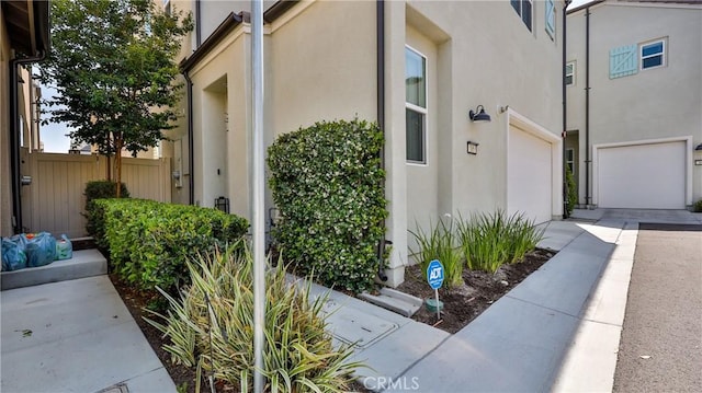 4173 Horvath St Unit 105, Corona, CA 92883 - doorway to property with stucco siding, an attached garage, and driveway