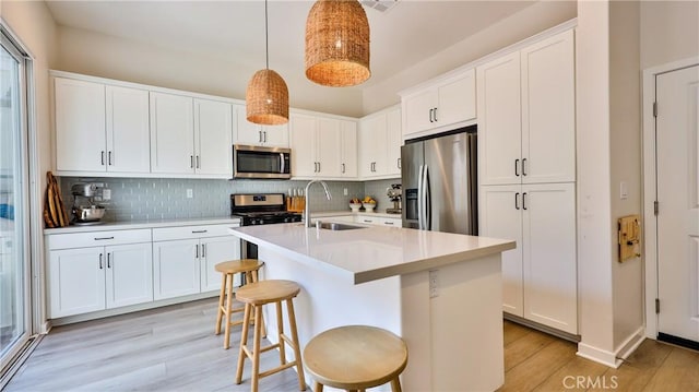 4173 Horvath St Unit 105, Corona, CA 92883 - kitchen featuring appliances with stainless steel finishes, light wood finished floors, tasteful backsplash, and light countertops