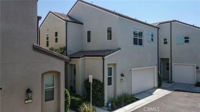 4173 Horvath St Unit 105, Corona, CA 92883 - view of front of home featuring stucco siding, a tiled roof, an attached garage, and driveway