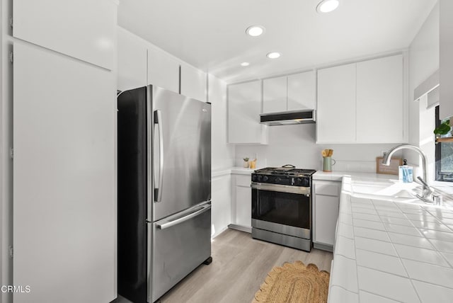 640 Orwell Ln, Ventura, CA 93003 - kitchen featuring appliances with stainless steel finishes, tile counters, extractor fan, light wood-style floors, and recessed lighting