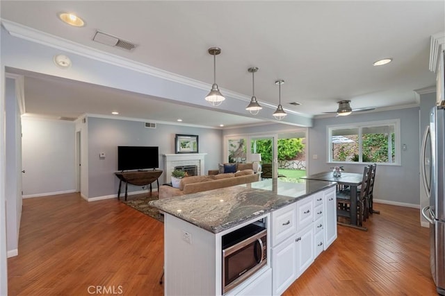 1827 Amelia Ave, San Pedro, CA 90731 - kitchen featuring appliances with stainless steel finishes, crown molding, dark stone countertops, white cabinetry, and light wood-style floors
