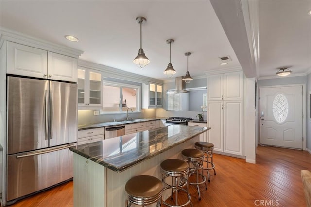 1827 Amelia Ave, San Pedro, CA 90731 - kitchen with stainless steel appliances, white cabinets, crown molding, glass insert cabinets, and a breakfast bar