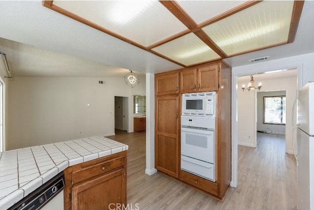 6318 Westview Dr, Riverside, CA 92506 - kitchen featuring a chandelier, white appliances, tile countertops, a warming drawer, and light wood-style flooring
