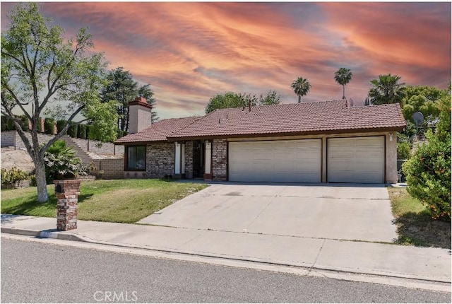6318 Westview Dr, Riverside, CA 92506 - single story home with a tiled roof, an attached garage, concrete driveway, a lawn, and a chimney