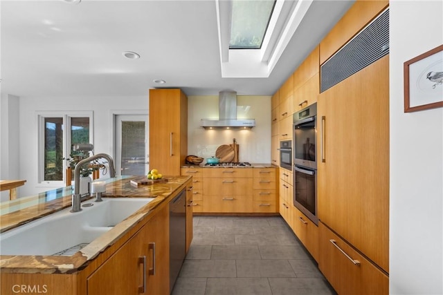 1372 Morningside Dr, Laguna Beach, CA 92651 - kitchen with wall chimney range hood, appliances with stainless steel finishes, a skylight, dark tile patterned flooring, and modern cabinets