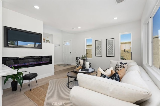 14941 Almond Grove Ct, Tustin, CA 92780 - living area with light wood-type flooring, recessed lighting, and a glass covered fireplace