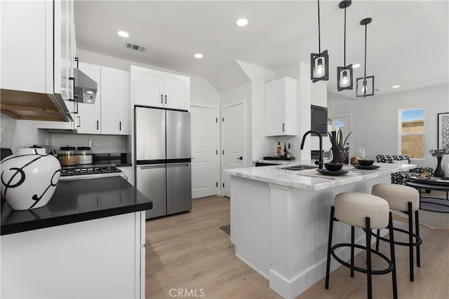 14941 Almond Grove Ct, Tustin, CA 92780 - kitchen featuring freestanding refrigerator, light wood-type flooring, white cabinets, a kitchen bar, and recessed lighting