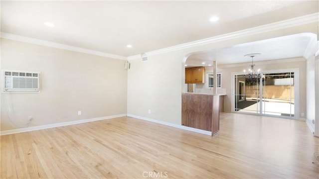 5449 E Fairbrook St, Long Beach, CA 90815 - unfurnished living room with a wall mounted AC, a chandelier, arched walkways, light wood-style flooring, and crown molding