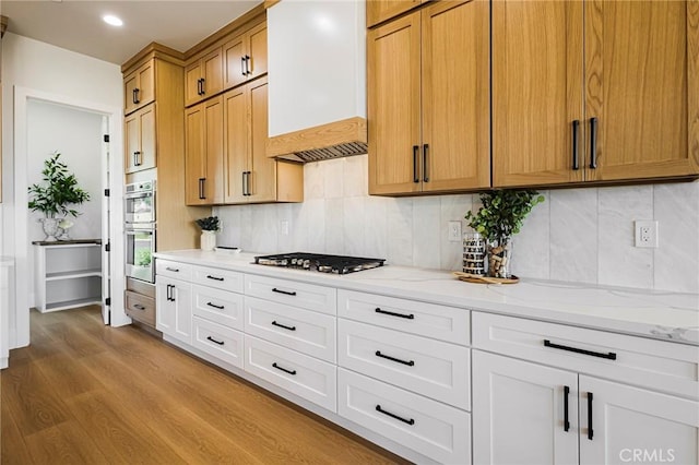 5891 Crestmoor Dr, Paradise, CA 95969 - kitchen with appliances with stainless steel finishes, tasteful backsplash, wood finished floors, light stone countertops, and premium range hood