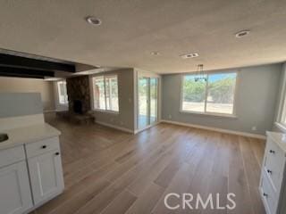 20219 Osseo Rd, Apple Valley, CA 92308 - unfurnished living room with wood finished floors, recessed lighting, and a fireplace