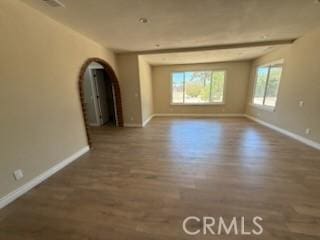 20219 Osseo Rd, Apple Valley, CA 92308 - empty room featuring arched walkways and wood finished floors