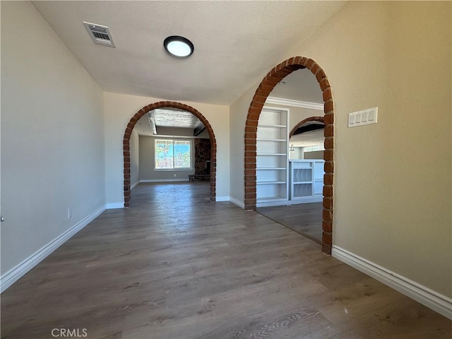 20219 Osseo Rd, Apple Valley, CA 92308 - corridor featuring arched walkways, wood finished floors, and built in features