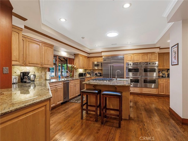 11485 Awenita Ct, Chatsworth, CA 91311 - kitchen with built in appliances, light stone counters, dark wood finished floors, decorative backsplash, and a kitchen breakfast bar